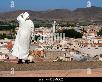 Homme portant une jellabah traditionnelle à la recherche à l'horizon d'Azrou, Maroc Banque D'Images