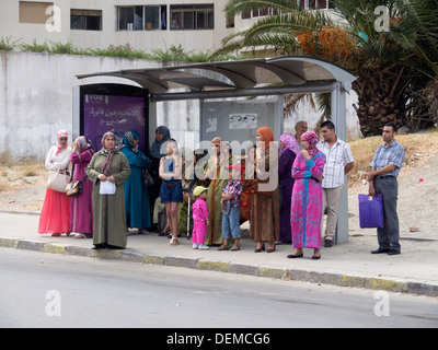 Personnes en attente d'un bus à un arrêt de bus, Fès, Maroc Banque D'Images