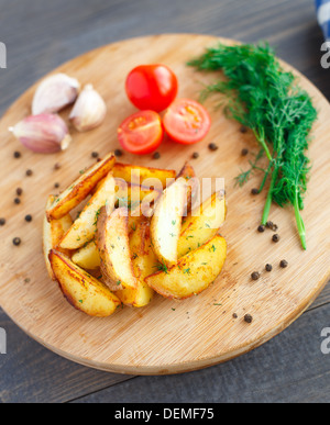 Quartiers de pommes de terre frites avec tomate cerise Banque D'Images