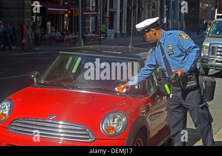 Un agent de la circulation de la ville de New York donne un billet pour un véhicule arrêté à un mètre sur expiration Broadway à New York City Banque D'Images