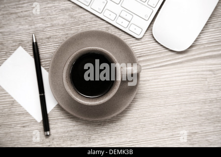 Image tonique, tasse de café noir, stylo, feuille de papier vierge, la souris et le clavier sur la table en bois Banque D'Images