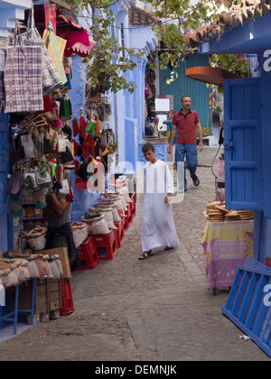 Jeune garçon et un homme marchant dans une rue à Chefchaouen, Maroc Banque D'Images