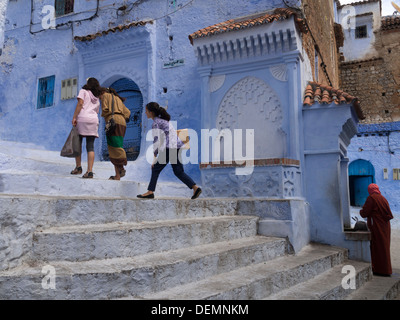 Trois enfants à pied vers le haut des escaliers à Chefchaouen, Maroc Banque D'Images