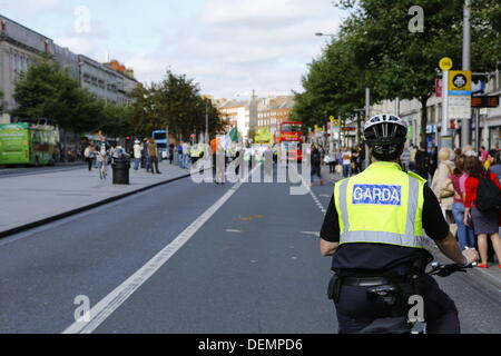 Dublin, Irlande. 21 septembre 2013. Un officier de garde irlandais (agent de police) sur son vélo observe le parti républicain Sinn Fein en couleur mars O'Connell Street. Le Sinn Fein républicain a tenu son assemblée veille du rallye Championnat la journée avant la finale All-Ireland football gaélique en dehors de la General Post Office (GPO), la place de l'Insurrection de Pâques 1916. Tout le président a juré de continuer la lutte pour une Irlande unie. Crédit : Michael Debets/Alamy Live News Banque D'Images