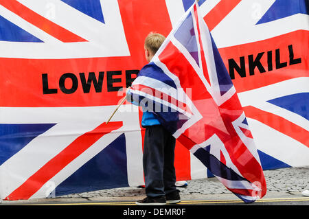 Belfast, en Irlande du Nord, 21 septembre 2013 - Un jeune garçon est titulaire d'un drapeau de l'Union européenne sur son épaule alors qu'il ressemble à un taux bien plus une qui dit 'Réduire' Shankill Crédit : Stephen Barnes/Alamy Live News Banque D'Images