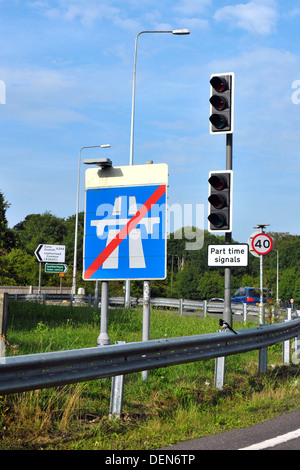 Un panneau routier indiquant la fin de l'autoroute à côté de feux de circulation. Banque D'Images