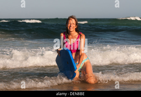 Ajustement mature femme en bonne santé (ou corps) boogey embarquement dans le surf à la Gold Coast. Banque D'Images