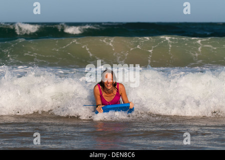 Ajustement mature femme en bonne santé (ou corps) boogey embarquement dans le surf à la Gold Coast. Banque D'Images