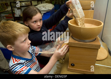 7 ans, fille et garçon de 5 ans, la farine de mouture du blé et d'orge à une semaine près de 24 fermes, haslemere Surrey, UK. Banque D'Images