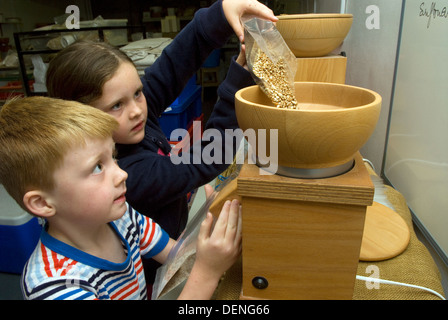 7 ans, fille et garçon de 5 ans, la farine de mouture du blé et d'orge à une semaine près de 24 fermes, haslemere Surrey, UK. Banque D'Images