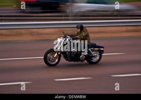 Synchro flash arrière technique utilisée pour capturer une moto Harley Davidson voyageant le long de la quatre voies à Dundee, Royaume-Uni Banque D'Images