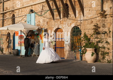 Un jeune couple le jour de leur mariage en tenant une une courte pause d'être photographiés à l'ancien port de Jaffa en Israël Banque D'Images