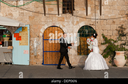 Un jeune couple le jour de leur mariage en tenant une une courte pause d'être photographiés à l'ancien port de Jaffa en Israël Banque D'Images