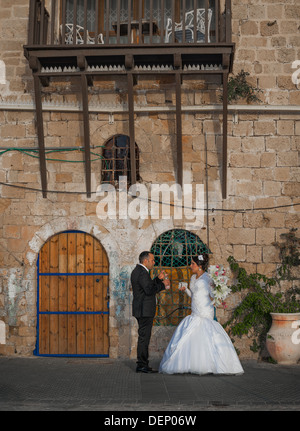 Un jeune couple le jour de leur mariage en tenant une une courte pause d'être photographiés à l'ancien port de Jaffa en Israël Banque D'Images