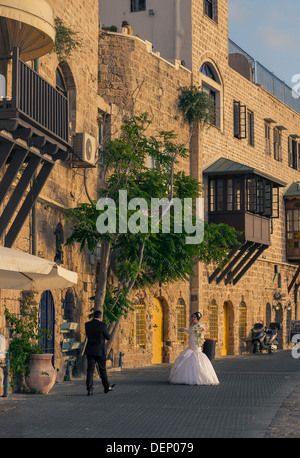 Un jeune couple le jour de leur mariage en tenant une une courte pause d'être photographiés à l'ancien port de Jaffa en Israël Banque D'Images