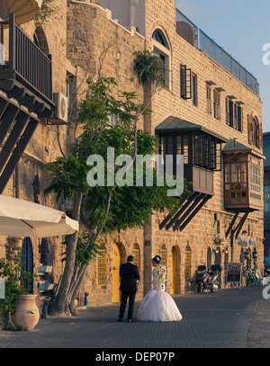 Un jeune couple le jour de leur mariage en tenant une une courte pause d'être photographiés à l'ancien port de Jaffa en Israël Banque D'Images