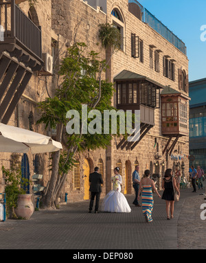 Un jeune couple le jour de leur mariage en tenant une une courte pause d'être photographiés à l'ancien port de Jaffa en Israël Banque D'Images
