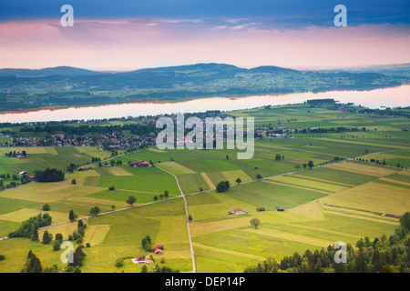 Photographie d'areal lire crossing, champs verts de rayures, arbres et maisons près de château de Neuschwanstein en Allemagne Banque D'Images