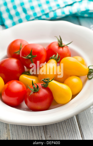 Les tomates dans un bol blanc coloré Banque D'Images
