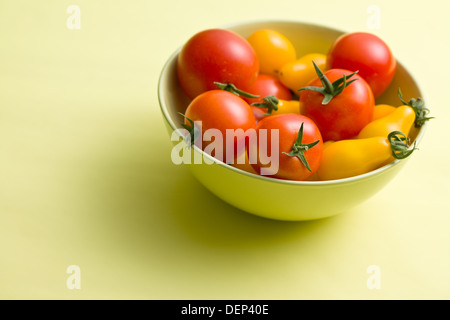 Divers les tomates dans bol sur fond coloré Banque D'Images