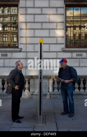 Deux touristes Londres lire un plan de ville d'informations poster dans Whitehal, Westminster. Banque D'Images