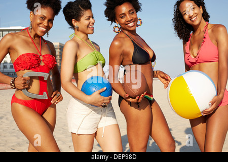 Women holding balls on beach Banque D'Images