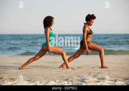 Women practicing yoga on beach Banque D'Images