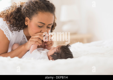 Mère hispaniques jouant avec lit bébé sur Banque D'Images