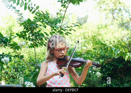 Hispanic girl playing violin outdoors Banque D'Images