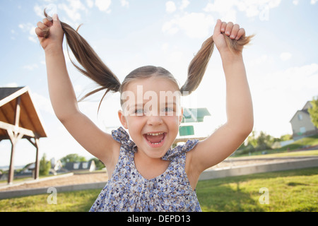 Caucasian girl Playing with pigtails outdoors Banque D'Images
