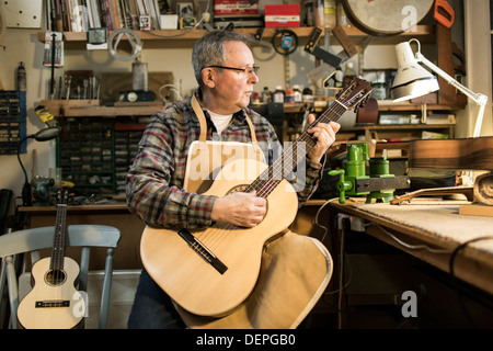 Tuning fabricant de guitares guitare acoustique et d'essai en atelier Banque D'Images