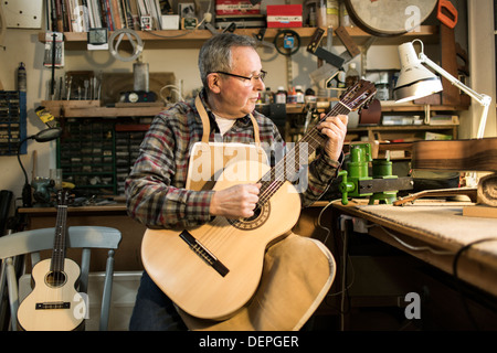 Tuning fabricant de guitares guitare acoustique et d'essai en atelier Banque D'Images