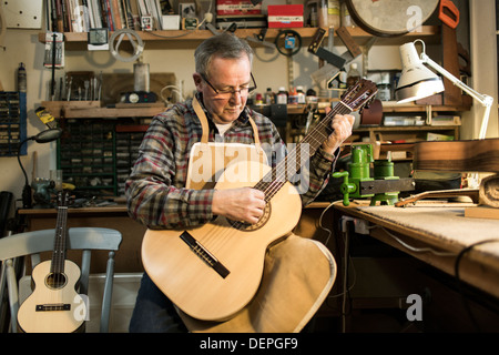 Tuning fabricant de guitares guitare acoustique et d'essai en atelier Banque D'Images