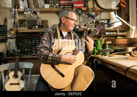 Tuning fabricant de guitares guitare acoustique et d'essai en atelier Banque D'Images