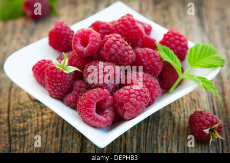 Framboises mûres et fraîches sur petite plaque Banque D'Images