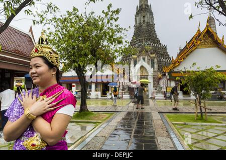 Bangkok, Thaïlande. 23 août, 2013. Des touristes posent pour des photos dressed in costumes de la cour royale de Thaïlande vers 1800 en face de l'prang central au Wat Arun. Le plus remarquable de la Wat Arun est son prang central (tour de style Khmer). La célèbre stupa sera fermé pendant trois ans pour l'exécution de certaines réparations et de rénovation ainsi que d'autres structures dans le temple composé. Ce sera le plus gros travail de réparation et de rénovation sur le stupa dans les 14 dernières années. Dans le passé, même à grande échelle alors que le travail était fait, le stupa utilisé pour rester ouvert aux touristes. Il peut être nommé ''Temple de la D Banque D'Images