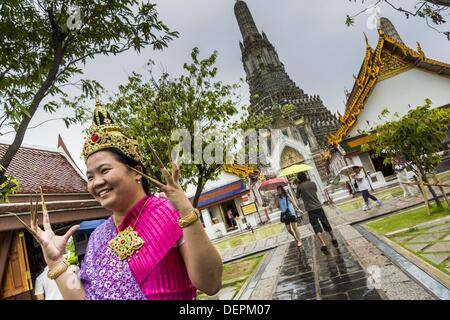 Bangkok, Thaïlande. 23 août, 2013. Des touristes posent pour des photos dressed in costumes de la cour royale de Thaïlande vers 1800 en face de l'prang central au Wat Arun. Le plus remarquable de la Wat Arun est son prang central (tour de style Khmer). La célèbre stupa sera fermé pendant trois ans pour l'exécution de certaines réparations et de rénovation ainsi que d'autres structures dans le temple composé. Ce sera le plus gros travail de réparation et de rénovation sur le stupa dans les 14 dernières années. Dans le passé, même à grande échelle alors que le travail était fait, le stupa utilisé pour rester ouvert aux touristes. Il peut être nommé ''Temple de la D Banque D'Images