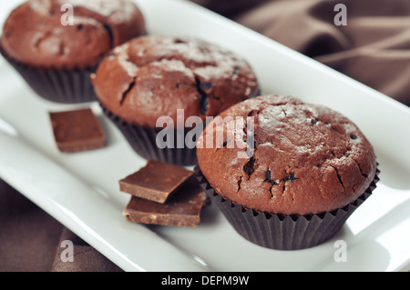 Muffins au chocolat sur plaque blanche sur fond de bois Banque D'Images