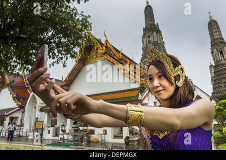 Bangkok, Thaïlande. 23 août, 2013. Des touristes posent pour des photos dressed in costumes de la cour royale de Thaïlande vers 1800 en face de l'prang central au Wat Arun. Le plus remarquable de la Wat Arun est son prang central (tour de style Khmer). La célèbre stupa sera fermé pendant trois ans pour l'exécution de certaines réparations et de rénovation ainsi que d'autres structures dans le temple composé. Ce sera le plus gros travail de réparation et de rénovation sur le stupa dans les 14 dernières années. Dans le passé, même à grande échelle alors que le travail était fait, le stupa utilisé pour rester ouvert aux touristes. Il peut être nommé ''Temple de la D Banque D'Images