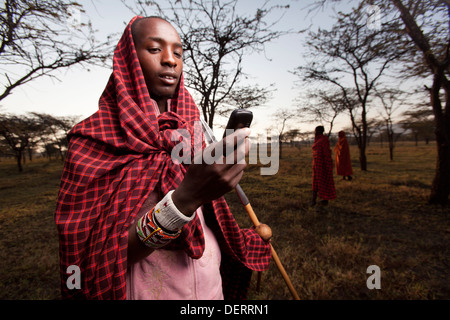 Homme Masai envoyer un message texte dans la région de Mara, Kenya, Banque D'Images