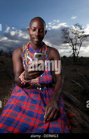 Homme Masai envoyer un message texte dans la région de Mara, Kenya, Banque D'Images