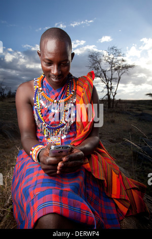 Homme Masai envoyer un message texte dans la région de Mara, Kenya, Banque D'Images