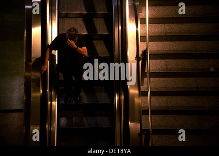 L'homme sur l'escalator dans le métro Banque D'Images