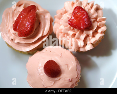 Trois petits gâteaux aux fraises faits maison, gros plan, sur une assiette blanche. Banque D'Images
