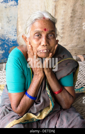 Old South Indian woman sitting on lit bébé Banque D'Images