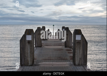 Vue d'horizon et fin de l'épi jetty avec plate-forme cachée d'Aberystwyth coucher de soleil avec des nuages rétroéclairé Banque D'Images