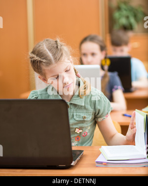 Les enfants de l'école à l'aide de pc portable à une leçon Banque D'Images