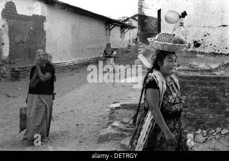 Les femmes mexicaines en vêtements traditionnels brodés Main Tehuantepec zapotèque de l'Oaxaca Huipil à célébrer fête du village en 1970 Tehuantepec Oaxaca. Mexique La nourriture transportée en panier sur sa tête avec un ballon sur un bâton. HOMER SYKES Banque D'Images