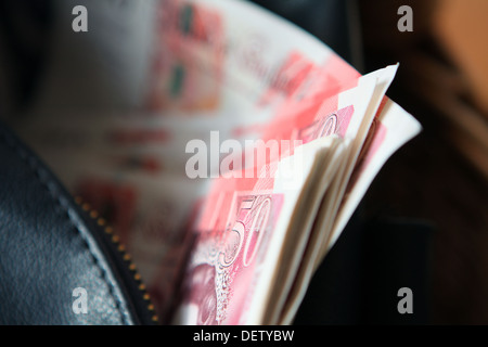 Sterling £50 notes dans un sac à main noir Banque D'Images