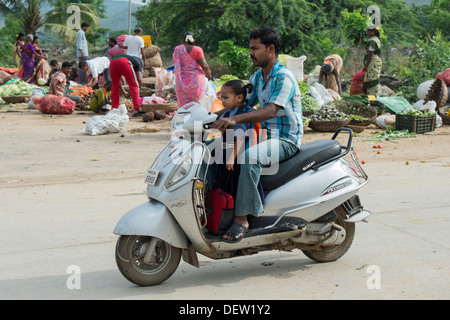 Prenant son père indien fille à l'école sur un cyclomoteur. L'Andhra Pradesh, Inde Banque D'Images